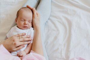 A newborn baby sleeps shortly after birth. Some birth injuries happen during labor or delivery and may not be visible right away.